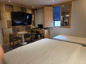 a hotel room with a bed and a desk and a television at Hotel DEAN in Incheon