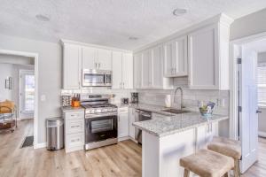 a kitchen with white cabinets and a stove top oven at Just Beachy in Lincoln City +33 photos