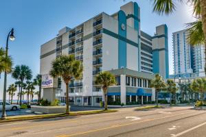 a building on a street with palm trees at Stunning Ocean Views, Elegant 1-bdr Condo 4th FL Boardwalk Beach Resort in Myrtle Beach