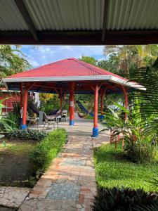 a pavilion with a red roof with a playground at Chinitas Eco Lodge in Tortuguero