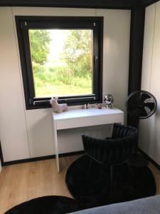 a room with a window with a sink and a chair at Ciekawy Domek 135 in Białki Dolne