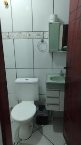 a bathroom with a white toilet and a sink at Pousada Fênix in Araripina