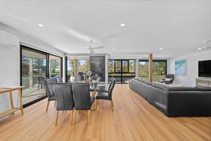 a living room with a black couch and chairs at Beachfront with pool ocean views and pet friendly in Buddina