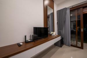 サヌールにあるBaruna Homestay Sanurの壁に薄型テレビが取り付けられたリビングルーム +9枚の写真