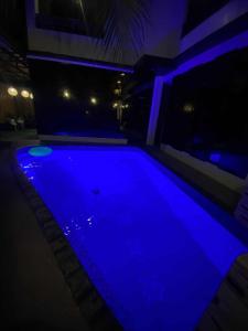 a swimming pool lit up in blue at night at Journey Inn in General Luna