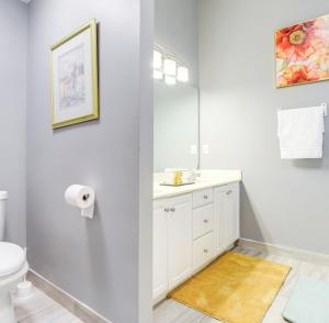 ein weißes Badezimmer mit Waschbecken und Spiegel in der Unterkunft Stylish Retreat in Lawrenceville in Lawrenceville + 19 Fotos