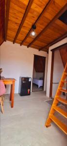 a room with a black refrigerator and a wooden ceiling at Chalé Pegada Real Vermelho in Sêrro