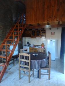une cuisine avec une table et des chaises ainsi qu'un escalier dans l'établissement Cabañas Nuestras Raices Potrerillos, à Potrerillos