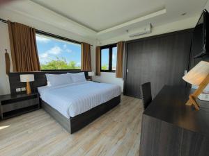 une chambre avec un lit, un bureau et une fenêtre dans l'établissement Telaga Villa Ungasan, à Uluwatu 22 autres photos