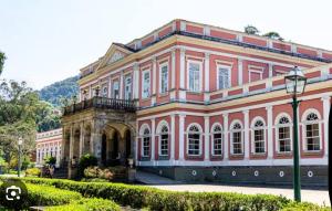 a large pink building with a lot of windows at Conforto próximo a tudo in Petrópolis