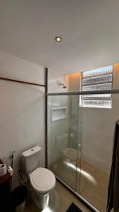 a bathroom with a toilet and a glass shower at Conforto próximo a tudo in Petrópolis
