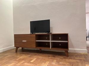 a wooden entertainment center with a flat screen tv on it at Conforto próximo a tudo in Petrópolis