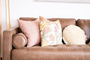a brown couch with pillows on top of it at Bateau Bay in Bateau Bay +30 photos