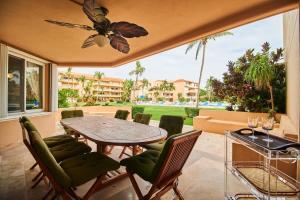a patio with a table and chairs and a large window at BeachFront Appt w/Amazing Pool in Puerto Aventuras in Puerto Aventuras