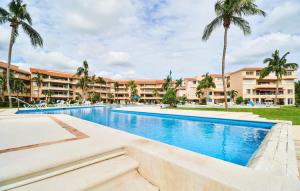 a swimming pool at a resort with palm trees at BeachFront Appt w/Amazing Pool in Puerto Aventuras in Puerto Aventuras