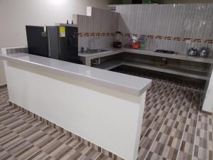 eine Küche mit einer weißen Theke und einem Kühlschrank in der Unterkunft Hotel Tari in Mocoa