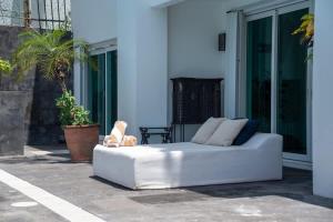 a white couch sitting outside of a building at Casa Coco - 4BR | Private Pool | Hotel Zone in Cancún