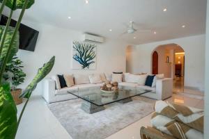a living room with a couch and a glass table at Casa Coco - 4BR | Private Pool | Hotel Zone in Cancún +42 photos