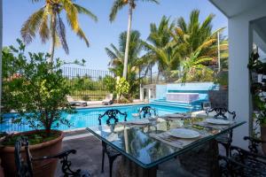 a patio with a table and chairs next to a pool at Casa Coco - 4BR | Private Pool | Hotel Zone in Cancún