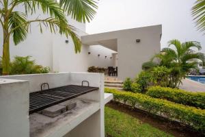 a white house with a barbecue in a yard at 3BR Modern House - Central & Fully Equipped in Cancún