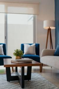 a living room with a table and a blue couch at 3BR Modern House - Central & Fully Equipped in Cancún +26 photos