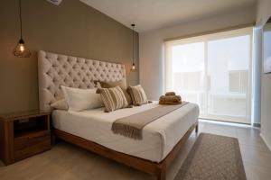 a bedroom with a large bed with a large window at 3BR Modern House - Central & Fully Equipped in Cancún