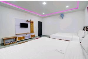 a white room with a bed and a tv at Coorg Crown Palace Resort kushalnagar in Jāmb