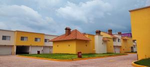 a row of yellow buildings in a parking lot at Hotel Destiny Inn Tula in Teocalco