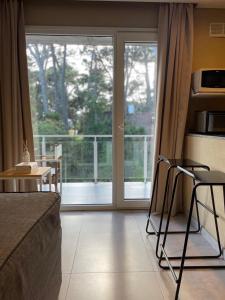 a bedroom with a bed and a sliding glass door at Nexo Playa Depto 6 in Valeria del Mar +4 photos