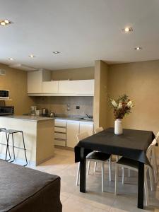 a kitchen and dining room with a black table with flowers on it at Nexo Playa Depto 6 in Valeria del Mar