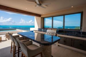 a kitchen with a counter with a view of the ocean at 9BR Luxury Beachfront Penthouse w/ Private Pool in Isla Mujeres +63 photos