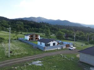 ein paar Häuser auf einem Feld mit einem Auto in der Unterkunft MV Cottages in Tsemi