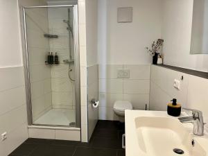 ein Badezimmer mit Dusche, Waschbecken und Toilette in der Unterkunft ROSIS HOME Geräumige Citywohnung im Herzen Schorndorfs - Ideal für Gruppen und Familen in Schorndorf + 24 Fotos