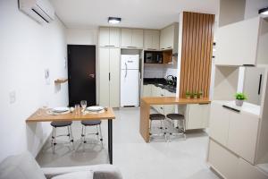 a kitchen with a table and chairs in a room at Studios Interlagos 201 in Araguari
