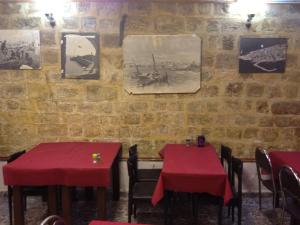 two tables in a restaurant with red table cloths at Akko Gate Hostel in Acre