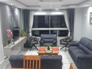 a living room with a couch and chairs and a table at Sea facing apartment 1703 on High Tide Amanzimtoti in Amanzimtoti