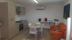 a kitchen with a small table and a kitchen with a couch at villa Fuga in Avola