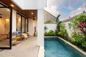 a swimming pool in the backyard of a house at Hati Villa by Betterplace in Canggu