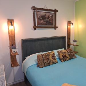 a bedroom with a bed with two pillows on it at Hostel Kuntur in Puerto Natales