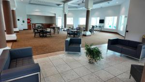 Un vestíbulo con sofás, mesas y sillas. en 110 - Next to Disney - Pool, en Orlando