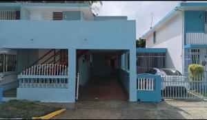 una casa con una puerta de entrada azul y un camino de entrada en San Antonio, en Aguas Buenas