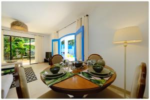 a dining room with a wooden table and chairs at Dar zeytouna in Hammamet