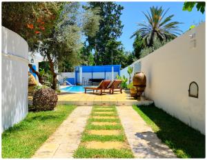 a backyard with a patio and a swimming pool at Dar zeytouna in Hammamet
