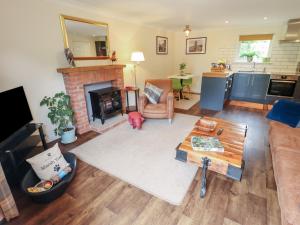 ein Wohnzimmer mit Couch und Kamin in der Unterkunft Marsh View Cottage in Skegness