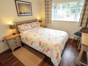ein Schlafzimmer mit Bett, Schreibtisch und Fenster in der Unterkunft Marsh View Cottage in Skegness