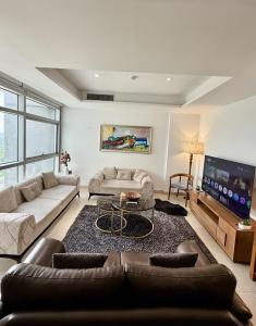 a living room with two couches and a tv at One Constitution Avenue by SUPERHOST STAYS in Islamabad