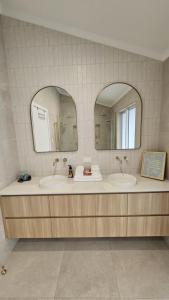 een badkamer met twee wastafels en twee spiegels bij Perfection in Pallarenda With Pool in Pallarenda