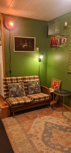 QT Apartment في كوينزتاون: غرفة معيشة مع أريكة وجدار أخضر