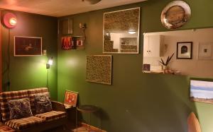 QT Apartment في كوينزتاون: غرفة معيشة مع أريكة وجدار أخضر +12 صورة