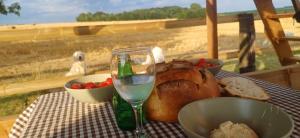 a table with a plate of bread and a glass of wine at Country lodge of Couvron 